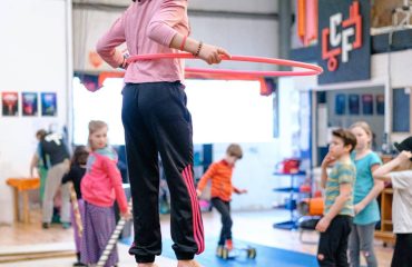 Young girl hula hooping on a globe walker ball